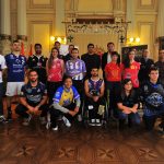 Los representantes de equipos de élite posan con los colores de sus respectivos equipos.